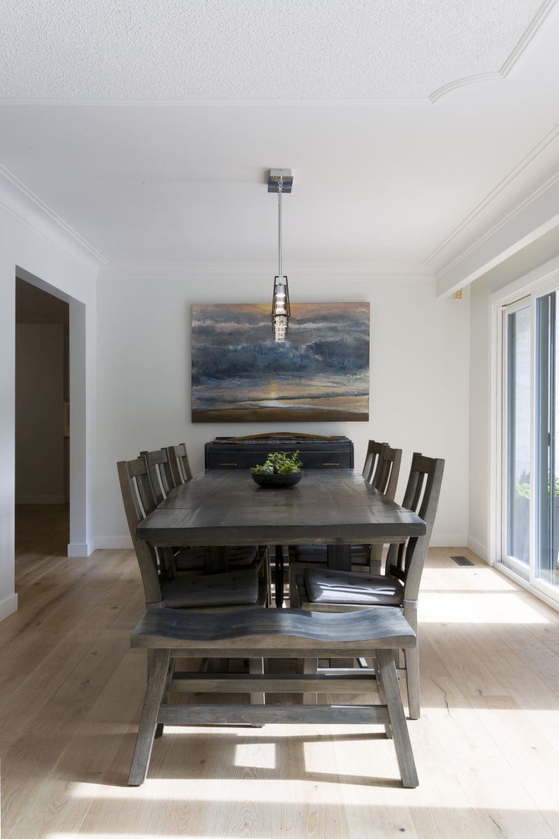Elegant dining room with natural light, modern lighting, and a large wood table. Perfect design inspiration for custom home builds or stylish renovations